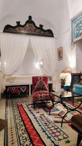 a living room with a red chair and a fireplace at Dar R'Bat in Nabeul