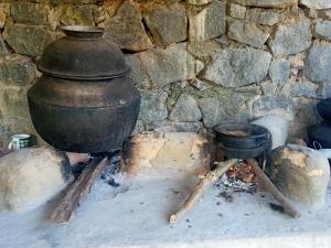 a large black pot sitting next to a stone wall at Galkotuwa Estate in Gelioya