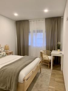 a bedroom with a bed and a desk and a window at Art'Estrela in Covilhã