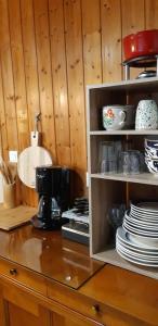 un bancone della cucina con macchinetta del caffè e piatti di Gîte le chalet vert , prêt de raquettes a Frambouhans