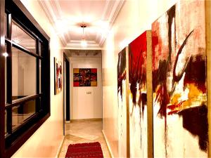 - un couloir orné de peintures sur les murs d'une chambre dans l'établissement Sab 9 - Great View Over Hassan Mosque. Luxurious 3 Bedrooms & 2,5 Bathrooms, à Casablanca