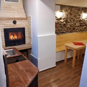 サパレヴァ・バニャにあるViBo Guesthouseのリビングルーム(暖炉、テーブル付)