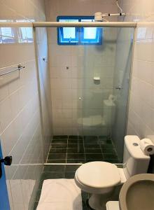a bathroom with a glass shower and a toilet at Pousada Barra Bonita in Bonito