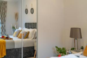 a bedroom with a bed and a mirror at Windsor Luxury Studio Apartment in Windsor