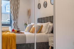 a bedroom with a bed with a mirror at Windsor Luxury Studio Apartment in Windsor