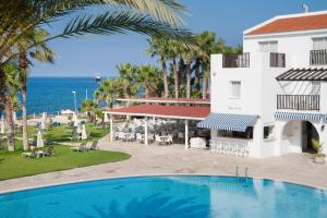 a view of a resort with a swimming pool and the ocean at Akti Beach Hotel & Village Resort in Paphos