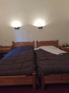 a bedroom with two beds and two lights on the wall at Apollon inn in Arachova