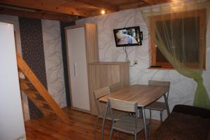 a dining room with a table and a television on a wall at Oaza Spokoju in Łokciowe