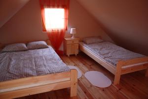 two beds in a attic bedroom with a window at Oaza Spokoju in Łokciowe