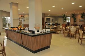 a restaurant with a counter with food on it at Poente Hotel in São Lourenço do Oeste