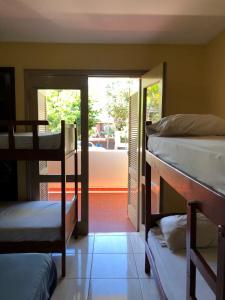a room with three bunk beds and a patio at La Casa de Pedro Hostel in Encarnación