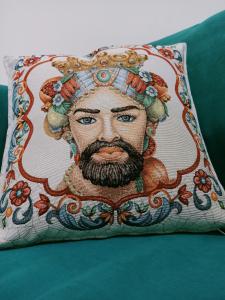 a pillow with a picture of a man with a beard at Bed&Book 'A parma in Salemi