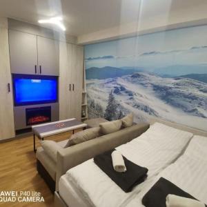 a living room with two beds and a large tv at Apartman Ice age Jahorina in Jahorina