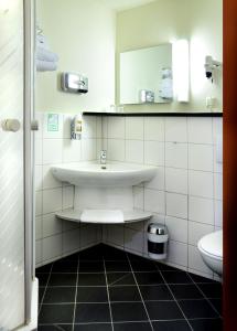 a bathroom with a sink and a toilet at Hotel Dom-Eck in Bautzen