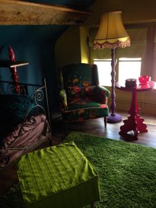 a living room with a chair and a lamp at Des goûts et des couleurs in Verviers