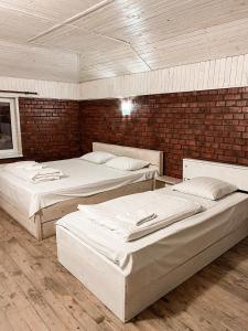 Habitación con 3 camas y pared de ladrillo en Guest House Lviv en Leópolis