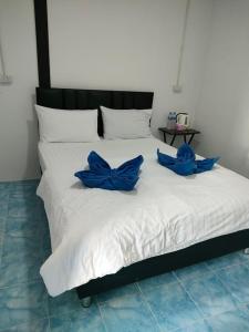 uma cama branca com arcos azuis em cima em Seahorse Lipe Hostel em Ko Lipe