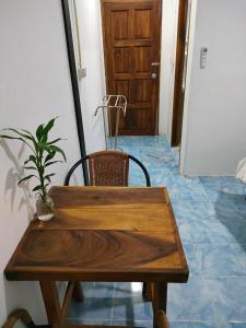 een houten tafel en stoel met een potplant erop bij Seahorse Lipe Hostel in Ko Lipe