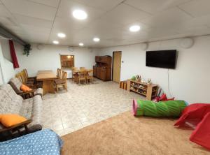 a living room with a television and a dining room at Penzion KUDLIK in Rudná pod Pradědem