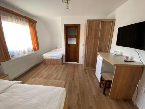 a bedroom with a bed and a desk and a television at Casa Mocanu in Sărmaş