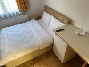 a small bedroom with a bed and a desk at Casa Mocanu in Sărmaş