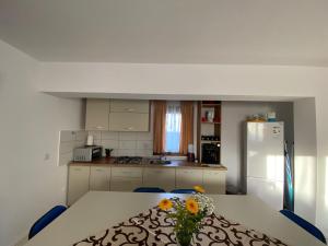 a kitchen with a table with a vase of flowers on it at Casa Mocanu in Sărmaş