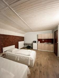 a large room with two beds and a kitchen at Guest House Lviv in Lviv