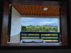 a room with a view of a balcony with a window at Tijota Hotel Fazenda in Ipatinga
