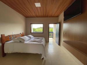 a bedroom with a bed and a window and a television at Tijota Hotel Fazenda in Ipatinga