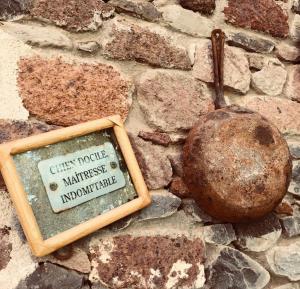 una placa en una pared de piedra junto a una bola de piedra en Ecolodge Kasa D'Igreja en Chã da Igreja