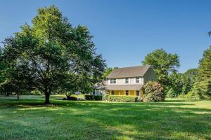 a house with a tree in the middle of a field at La Maison des Ours in Earlysville