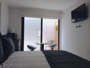 a bedroom with a bed and a television and a table at Departamentos Vellemar Reñaca in Viña del Mar