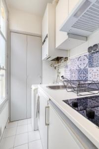 - une cuisine blanche avec évier et cuisinière dans l'établissement * Le Versaillais*2 min à pied du Château, à Versailles
