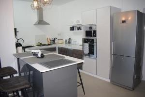 a kitchen with a refrigerator and a table and chairs at Equinox Kite Villa in La Gaulette