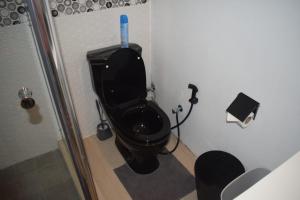 baño con aseo negro con cepillo azul en Equinox Kite Villa, en La Gaulette 25 fotos más