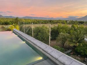 a swimming pool with a view of the mountains at 373 Wolmar Cosy and Modern Apartment- 200 metres from the Beach and Supermarkets and just next to Domaine de wolmar with views of deers and green natural park in Flic-en-Flac