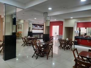 a restaurant with tables and chairs and a bar at Pousada M&atilde;e Ternura palace in Aparecida
