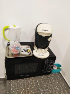 una macchinetta del caffè seduta sopra un forno a microonde di Chambre lit double a Chambray-lès-Tours