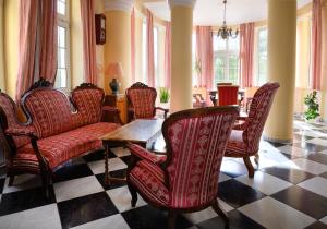 - un salon avec des chaises, une table et des fenêtres dans l'établissement Boros Kastély Vendégház, à Fonyód