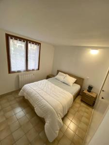 ein Schlafzimmer mit einem weißen Bett und einem Fenster in der Unterkunft Cosy and relax, appartement privé à GAP avec Parking in Gap
