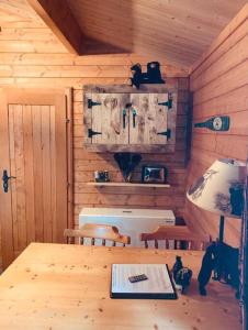 drewniany domek z drewnianym stołem i krzesłami w obiekcie Honeybear Hideaway Cabin w mieście Hayward