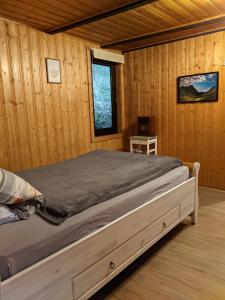 um quarto com uma cama num chalé de madeira em Waldnest Odenwald - Waldhauszimmer em Wald-Michelbach