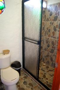 a bathroom with a toilet and a shower stall at Casa Encuentro Alojamiento Rural in Guatapé