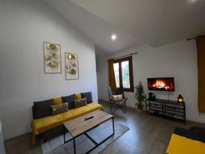 ein Wohnzimmer mit einem Sofa und einem Kamin in der Unterkunft appartement au coeur de Loupiac in Loupiac-de-Cadillac