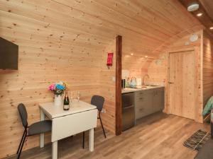 a kitchen and dining room of a log cabin with a table and chairs at Jenny - Crossgate Luxury Glamping in Penrith
