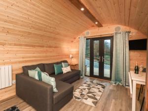 una sala de estar con sofá en una cabaña de madera en Jenny - Crossgate Luxury Glamping en Penrith