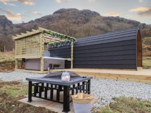 a picnic table with a grill in front of a building at Jenny - Crossgate Luxury Glamping in Penrith