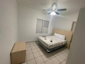 New updated 2 Bedroom Apartment in Bayamon, Puerto Rico في بايامون: غرفة نوم بسرير ومروحة سقف