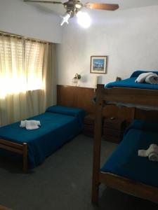 a bedroom with two beds and a ceiling fan at Hotel La Argentina in San Clemente del Tuyú