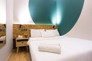 a bedroom with a bed with a blue and white wall at i-Hotel Kuala Lumpur in Kuala Lumpur